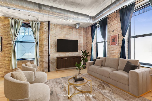 110 N Peoria St Unit 205, Chicago, IL 60607 - living room with brick wall, wood finished floors, and rail lighting