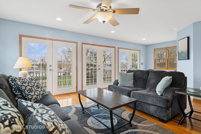living area with french doors, ceiling fan, and wood finished floors