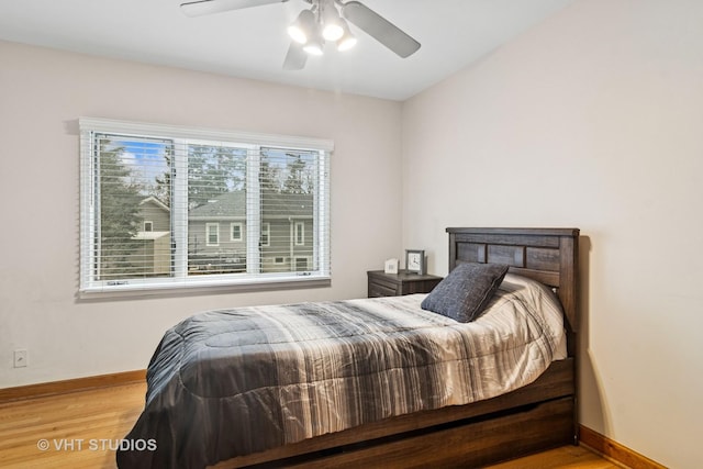 bedroom featuring wood finished floors, baseboards, and a ceiling fan