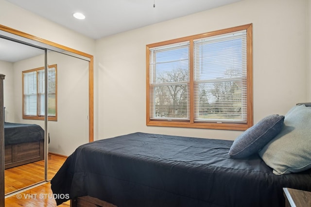 bedroom with light wood-style flooring, a closet, and recessed lighting