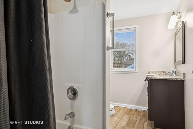 bathroom featuring baseboards, shower / bath combo with shower curtain, vanity, and wood finished floors