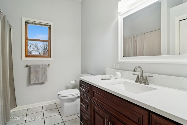 bathroom featuring tile patterned flooring, vanity, baseboards, and toilet