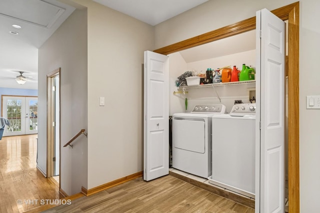 laundry area featuring baseboards, light wood-type flooring, attic access, laundry area, and washing machine and clothes dryer