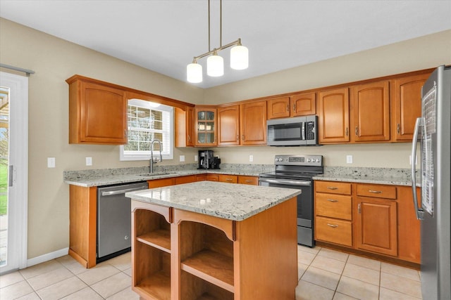 kitchen with brown cabinetry, a sink, light tile patterned floors, and stainless steel appliances