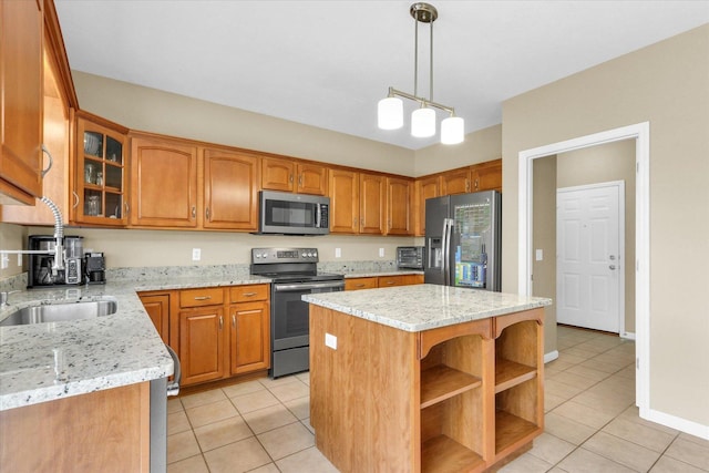 kitchen with a kitchen island, glass insert cabinets, brown cabinets, appliances with stainless steel finishes, and light tile patterned floors