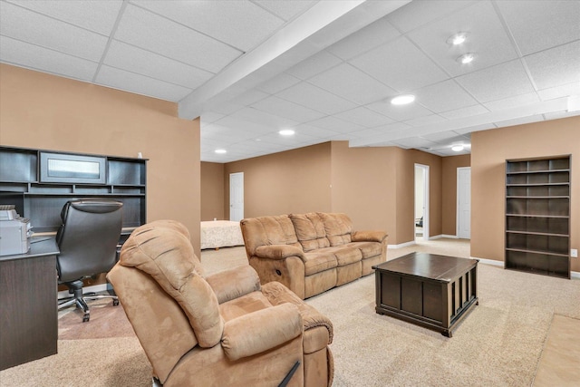 carpeted living area featuring baseboards, a drop ceiling, and recessed lighting