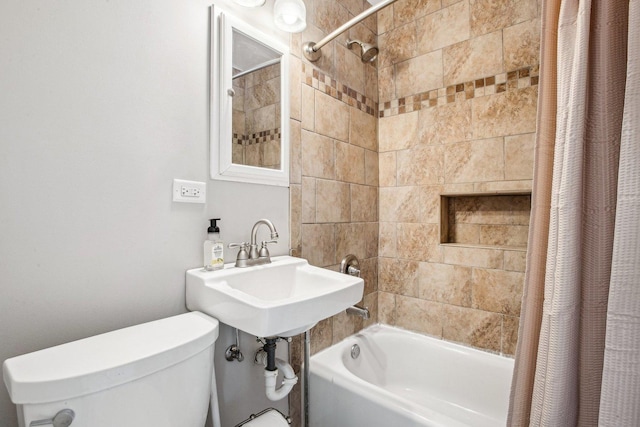 bathroom featuring toilet, a sink, and shower / bath combo