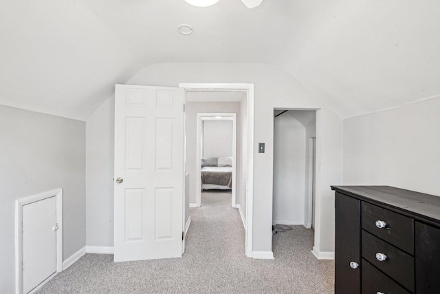 additional living space with light carpet, baseboards, and lofted ceiling