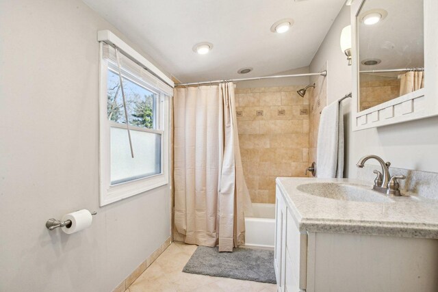 bathroom featuring shower / bath combo with shower curtain, vanity, tile patterned floors, and baseboards