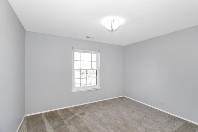 empty room featuring visible vents, carpet floors, and baseboards