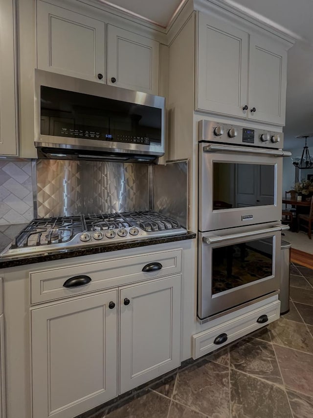 kitchen with decorative backsplash, appliances with stainless steel finishes, and dark countertops