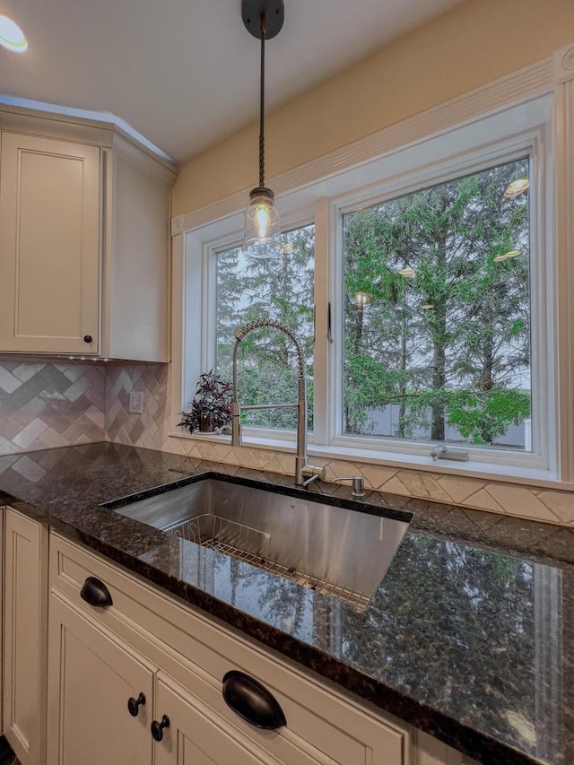kitchen with backsplash, pendant lighting, a healthy amount of sunlight, and a sink
