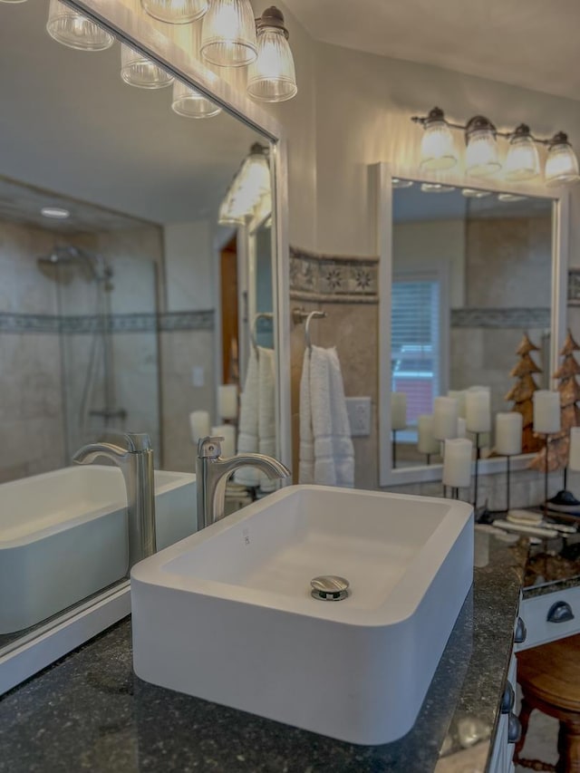 bathroom featuring a sink, tile walls, wainscoting, and walk in shower