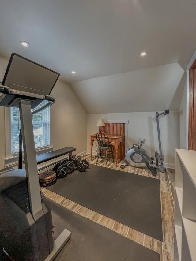 exercise room with baseboards, vaulted ceiling, recessed lighting, and wood finished floors