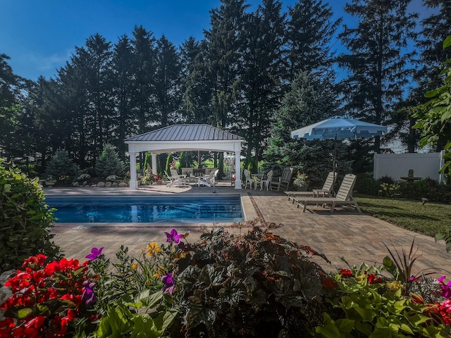 outdoor pool with a gazebo, fence, and a patio area