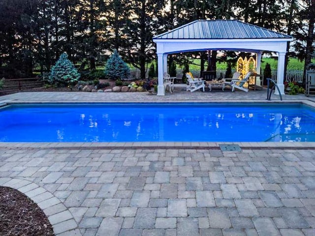 outdoor pool featuring a gazebo, fence, and a patio area