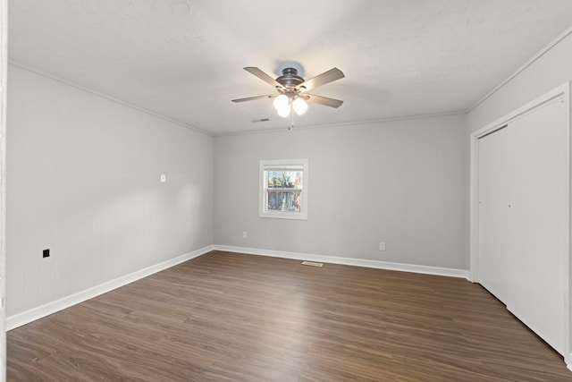 120 Anderson Ave, Joliet, IL 60433 - unfurnished bedroom featuring dark wood-style floors, ornamental molding, baseboards, ceiling fan, and a closet