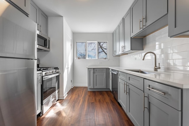 4313 Elm Ave, Lyons, IL 60534 - kitchen with stainless steel appliances, gray cabinetry, dark wood finished floors, tasteful backsplash, and light stone countertops