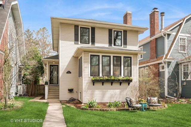 american foursquare style home featuring a front lawn