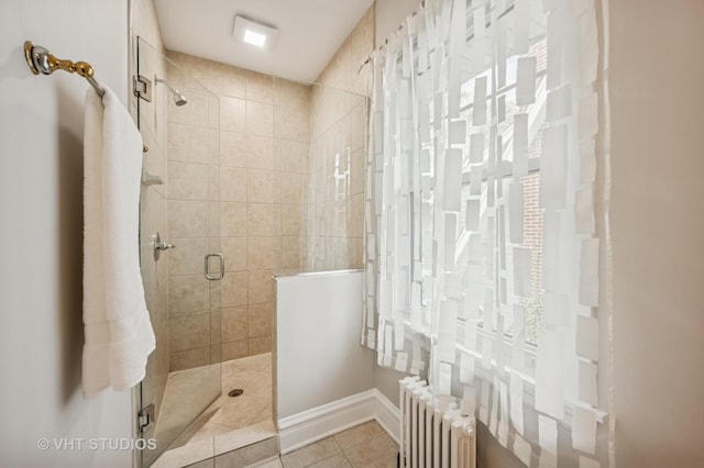 bathroom featuring a shower stall, radiator, and tile patterned flooring