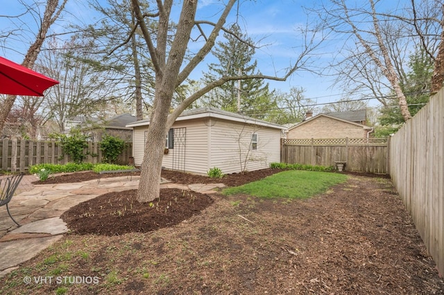 view of yard with a fenced backyard, an outdoor structure, and a patio