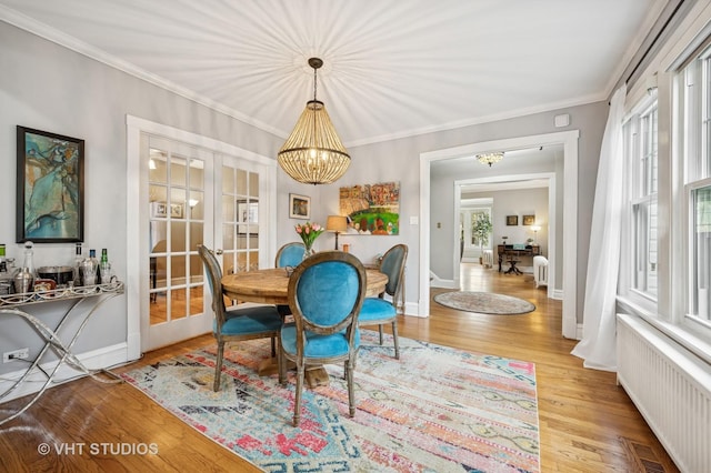 sunroom / solarium featuring a chandelier, radiator heating unit, visible vents, and french doors