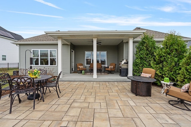 view of patio featuring outdoor dining area, fence, and a ceiling fan