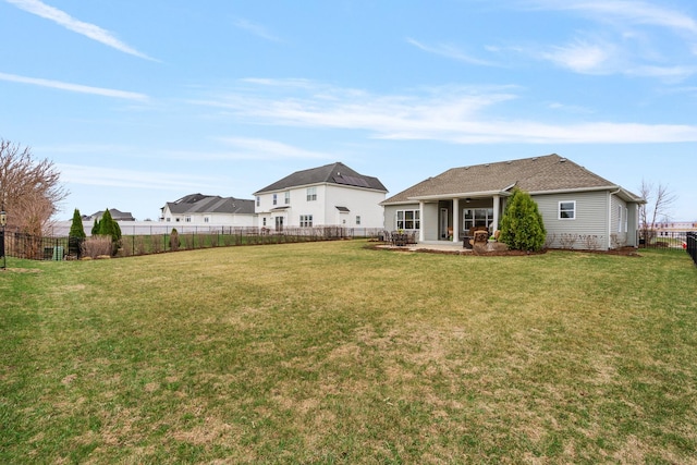 back of house with a fenced backyard, a patio, and a lawn