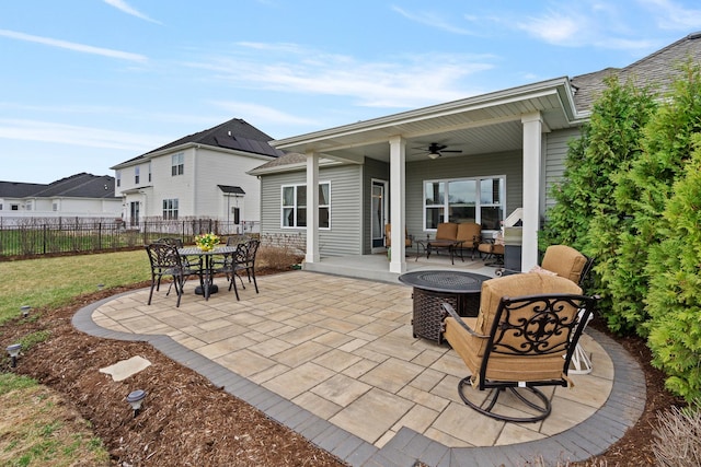 view of patio featuring a fire pit, fence, central AC unit, outdoor dining area, and ceiling fan