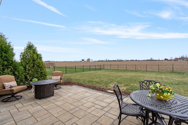 view of patio / terrace with a fenced backyard, outdoor dining area, central AC unit, and a rural view