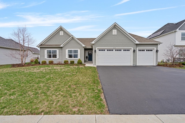 view of front of home with driveway, an attached garage, and a front lawn