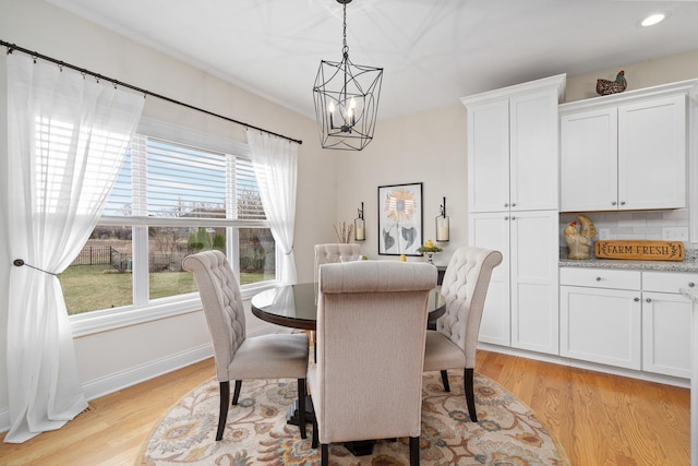 dining area with baseboards, a notable chandelier, light wood-style flooring, and recessed lighting