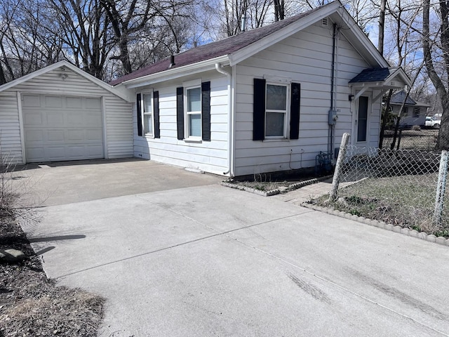 view of front of house with roof with shingles, concrete driveway, fence, and an attached garage