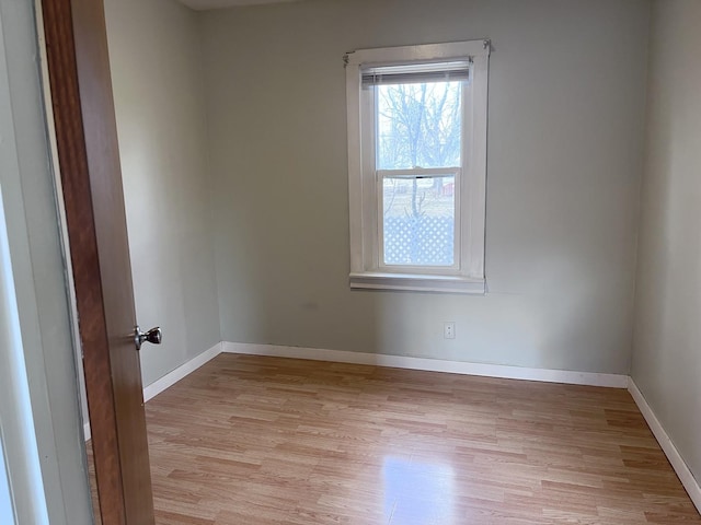 unfurnished room featuring baseboards and light wood-type flooring