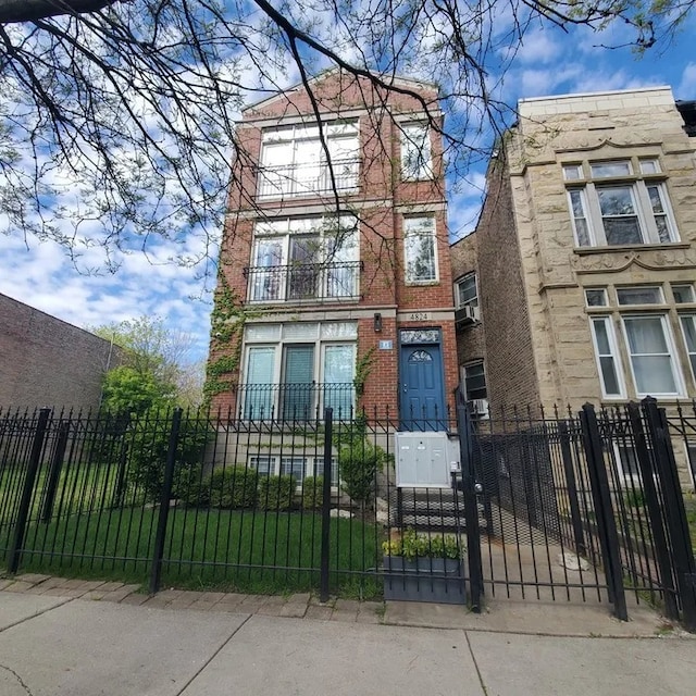 view of front facade with a fenced front yard, a gate, and brick siding