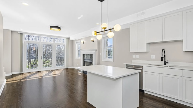 kitchen featuring dishwasher, light countertops, a sink, and visible vents