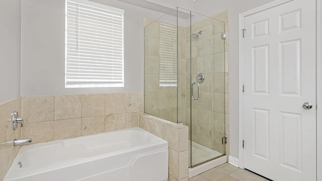 bathroom featuring a garden tub, a stall shower, and tile patterned floors