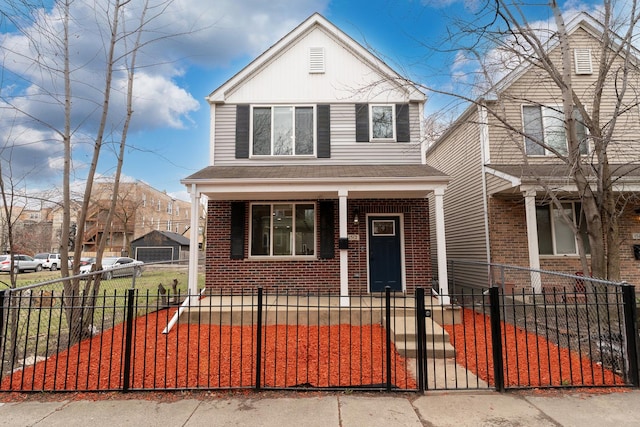 view of front of property with covered porch, brick siding, a gate, and a fenced front yard