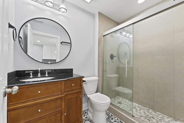 full bathroom featuring toilet, a stall shower, and vanity