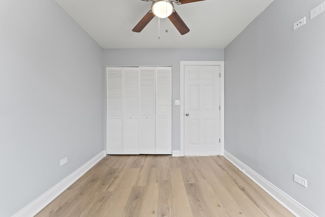 unfurnished bedroom featuring light wood finished floors, baseboards, a closet, and a ceiling fan
