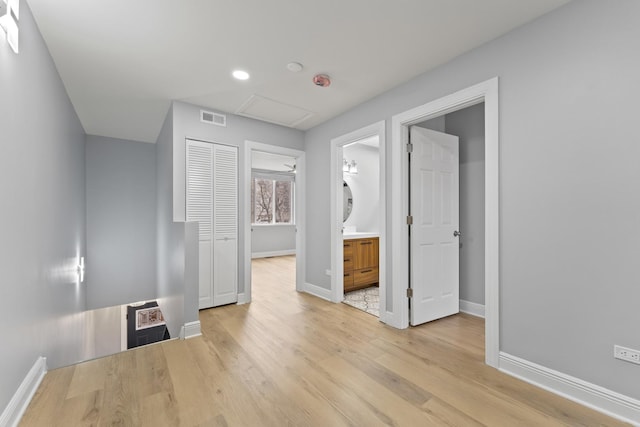 interior space with light wood-style flooring, visible vents, baseboards, recessed lighting, and ensuite bath