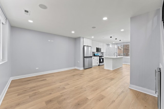 unfurnished living room with light wood-type flooring, recessed lighting, baseboards, and visible vents