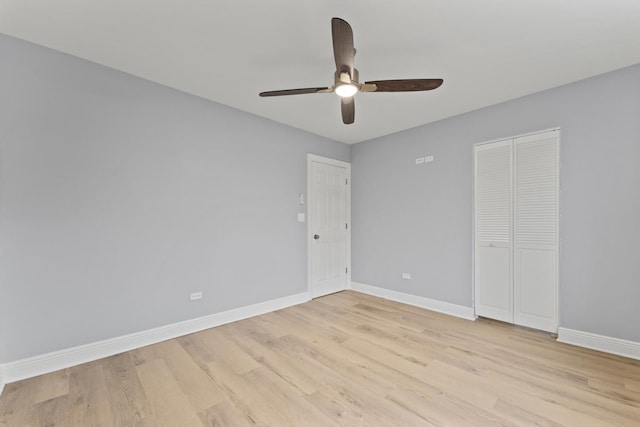 spare room featuring baseboards, light wood-style floors, and ceiling fan