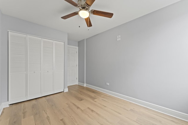 unfurnished bedroom featuring baseboards, ceiling fan, light wood-style flooring, and a closet