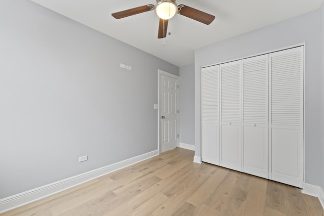 unfurnished bedroom with baseboards, a ceiling fan, a closet, and light wood-type flooring