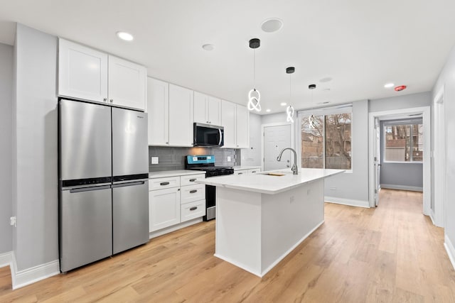 kitchen featuring light countertops, stainless steel appliances, backsplash, a sink, and white cabinets