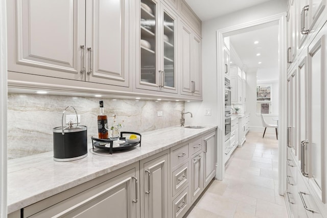 bar with decorative backsplash, stone finish floor, ornamental molding, recessed lighting, and a sink