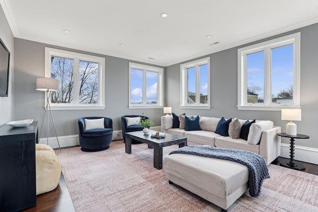 living area featuring baseboards, visible vents, ornamental molding, and wood finished floors