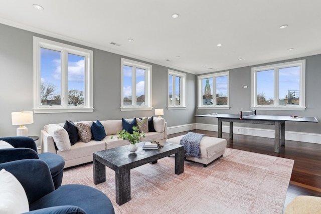 living room featuring baseboards, visible vents, wood finished floors, and ornamental molding