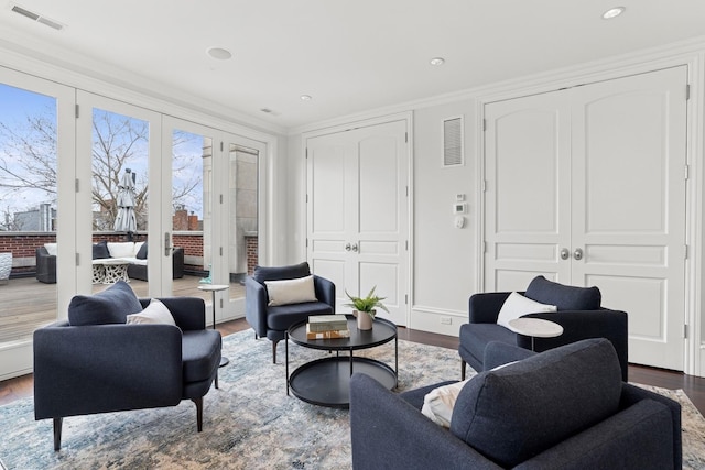 living room featuring visible vents, recessed lighting, wood finished floors, and ornamental molding